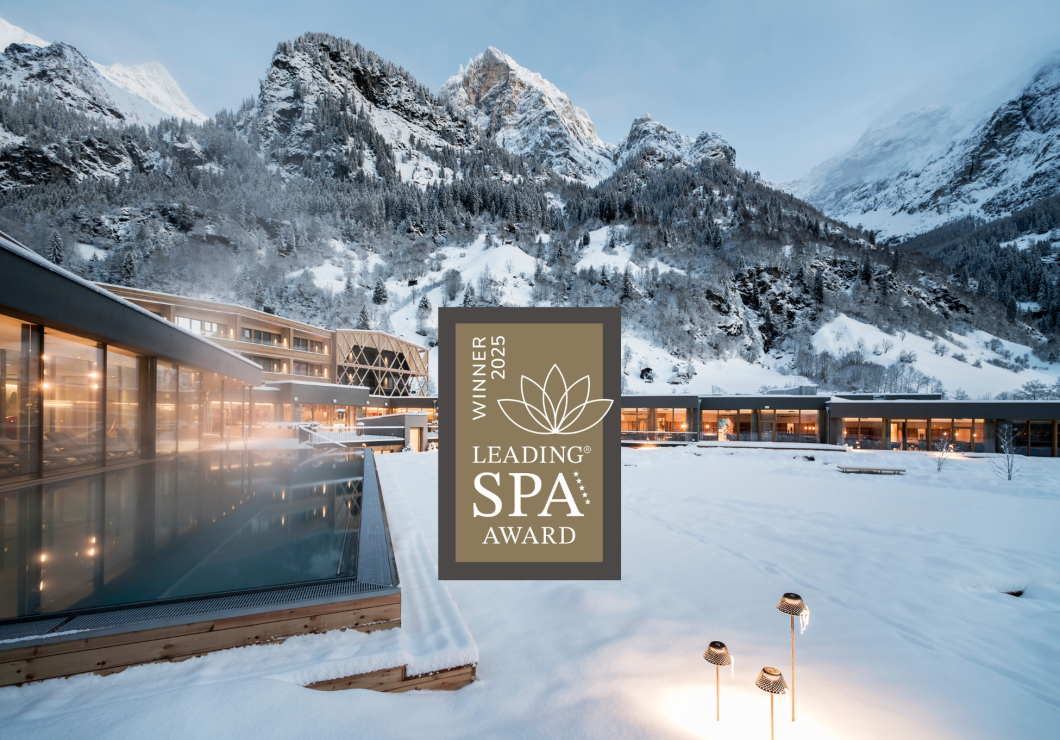 The Feuerstein outdoor pool in the snow and the Leading Spa Award Winner 2025 logo.