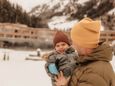 Father holding his child in front of the hotel in winter