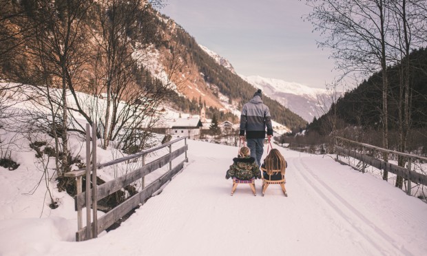 Davanti al Feuerstein, un padre traina i suoi bambini sulla slitta.