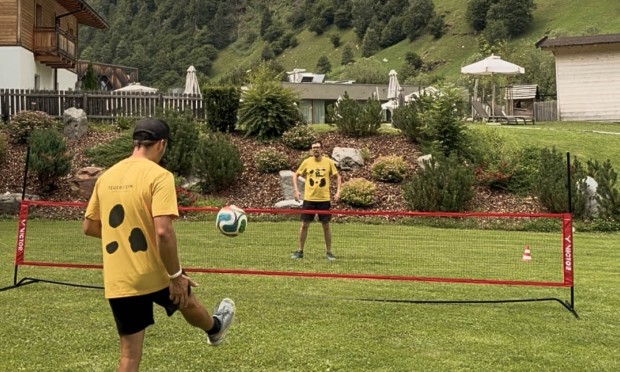 zwei Männer spielen Fussball über ein Netz, Fussballtennis.