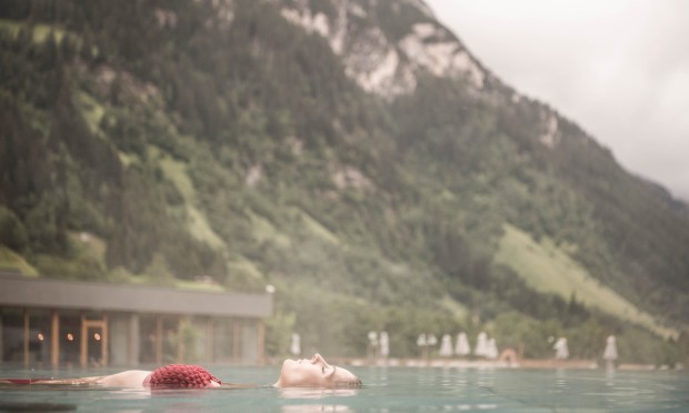 Piscina a sfioro al Feuerstein, donna sdraiata sulla schiena nell'acqua che si gode il momento