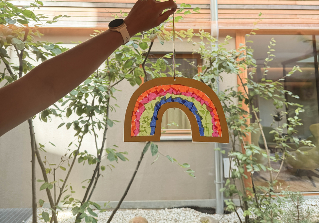 A homemade rainbow hanging in the window, glowing beautifully.