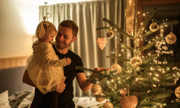 A father with his child in front of the Christmas tree