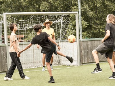 1 uomo con 2 ragazzi e un animatore mentre giocano a calcio