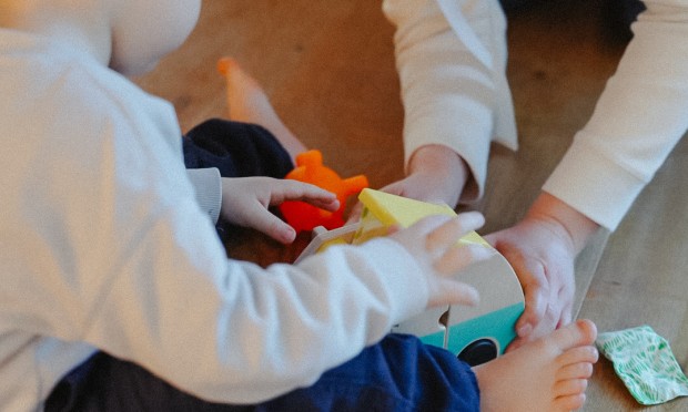 Saski helps a child build something