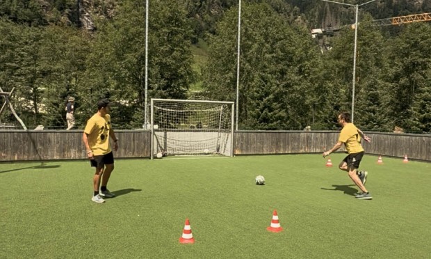 2 Männer auf Fussballfeld und schießen Tor.