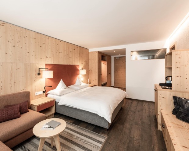 A bedroom with a sofa and TV at the children's hotel in South Tyrol.