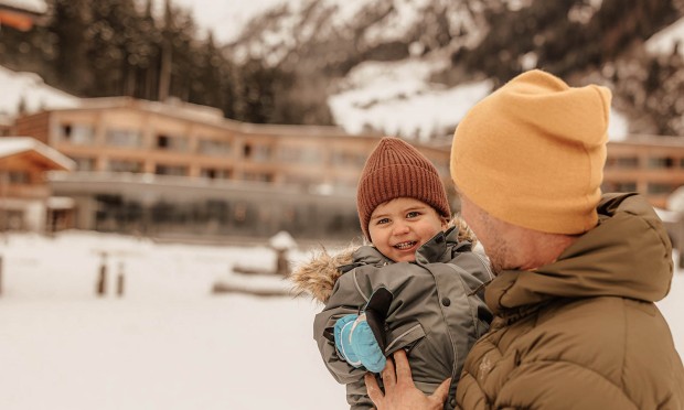 Winterbild von Jungen und Vater, beide sehen sehr glücklich aus und lachen