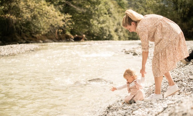 La madre cammina con il bambino lungo il fiume
