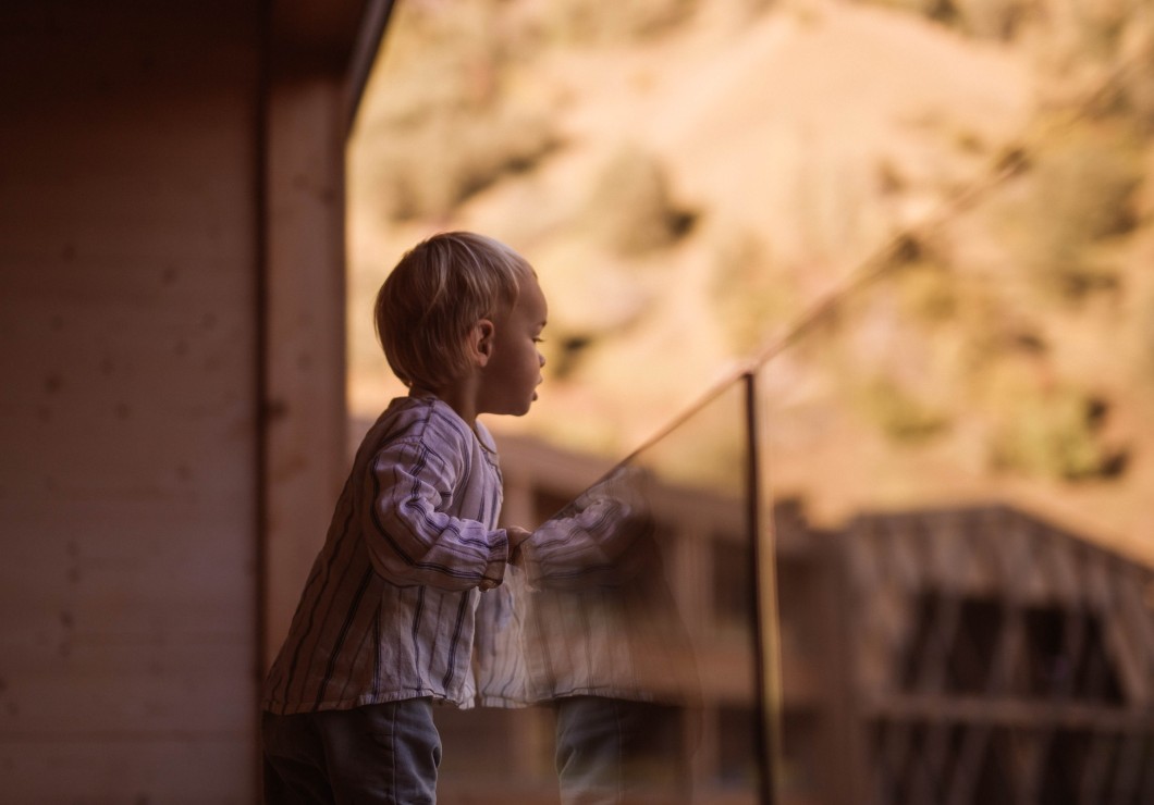 Kleines Kind schaut vom Balkon