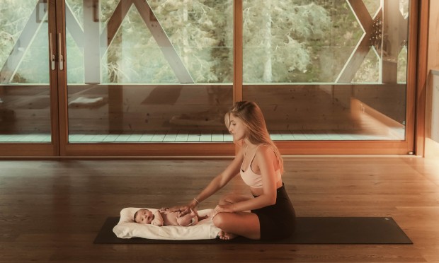 Mother sitting on the floor playing with her baby