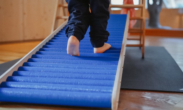 Toddler walks with feet on a rolling device