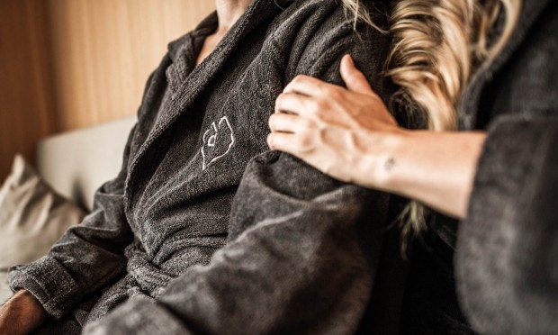 A woman's hand touches a man's shoulder.