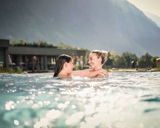 A mother and daughter are playing in the outdoor pool at a children's hotel in South Tyrol.