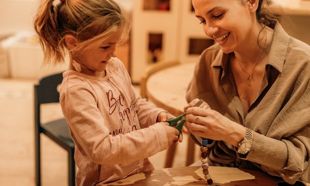 Kleines Mädchen schneidet etwas mit einer Schere durch