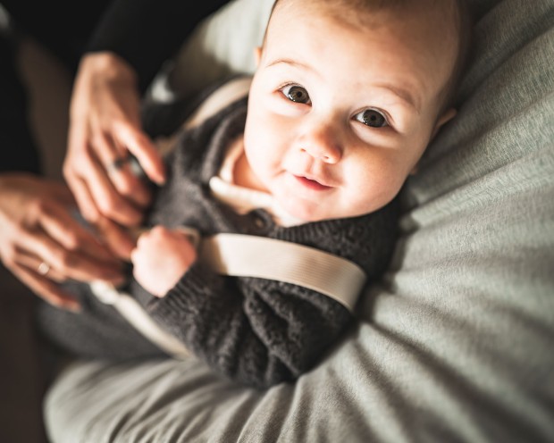 Kleines Baby wird von Mutter angezogen