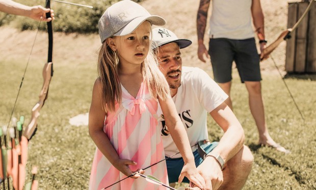 Kleines Mädchen versucht sich im Bogenschießen