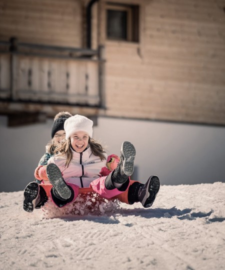 2 Kinder rutschen den Hügel hinunter