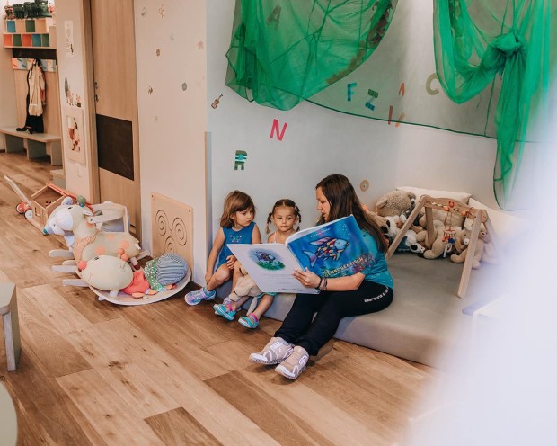 L'assistente legge un libro ai bambini.