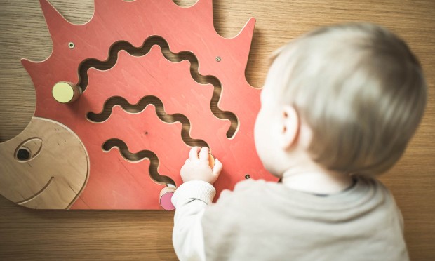 Baby spielt mit Holzspielzeug
