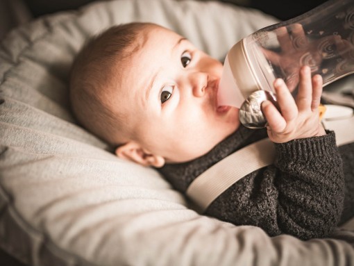 Il bambino beve acqua dalla bottiglia