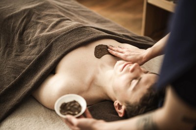Un uomo sdraiato riceve un trattamento peeling al petto con ciotola