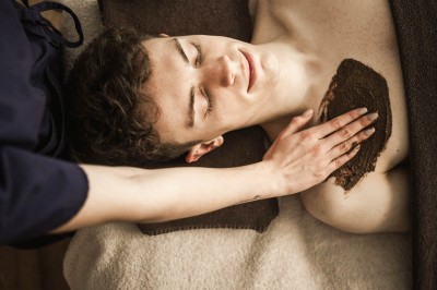 Un uomo sdraiato riceve un trattamento peeling al petto