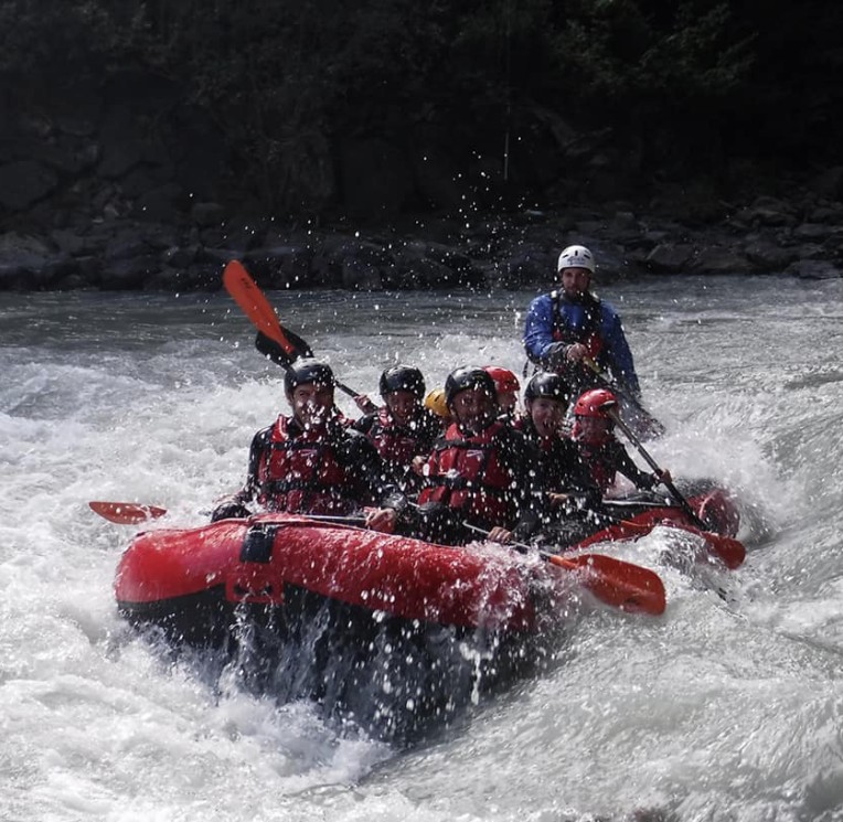 Gruppo di persone fa rafting su un fiume impetuoso in Alto Adige
