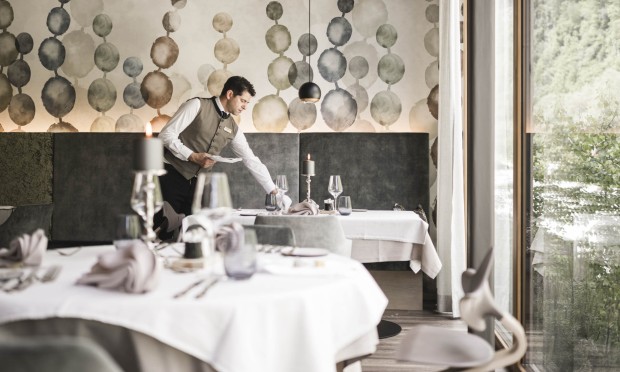 Sala da pranzo elegante con tavoli apparecchiati e decorazioni moderne