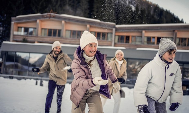 Kinder und Eltern spielen im Schnee