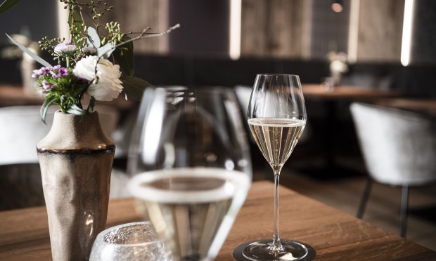 Tavolo apparecchiato con bicchieri da vino e decorazioni raffinate