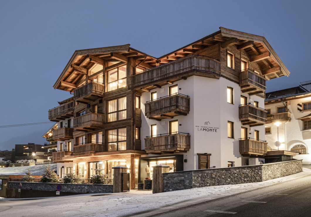 LaMonte Kitzbühel illuminato al tramonto con luci calde e cielo serale