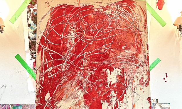 Eine große Leinwand mit bunten abstrakten Farbklecksen in einem kreativen Atelier.