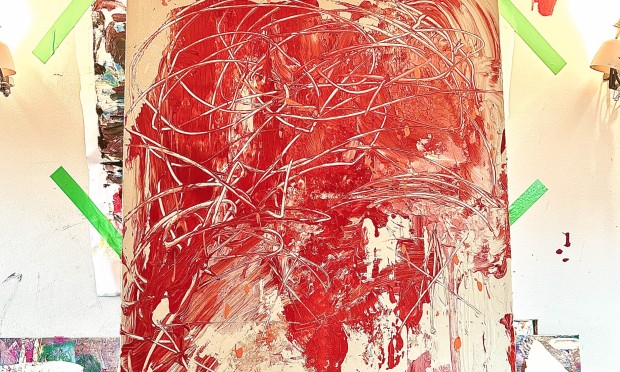 Un dipinto astratto con linee rosse e colori vivaci su un cavalletto