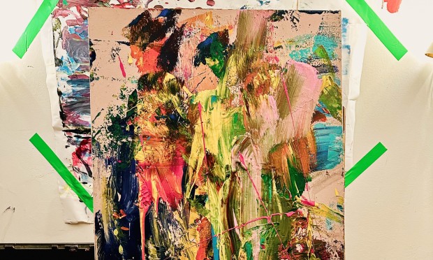 Un quadro astratto colorato è esposto su un cavalletto da pittura