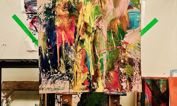 Ein farbenfrohes Kunstwerk mit lebhaften Pinselstrichen in einem Atelier.