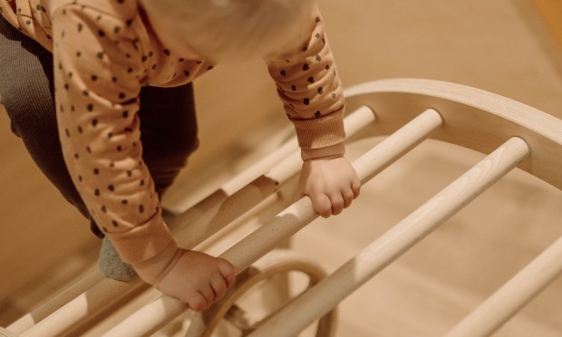 Bambino piccolo si arrampica su una struttura di legno