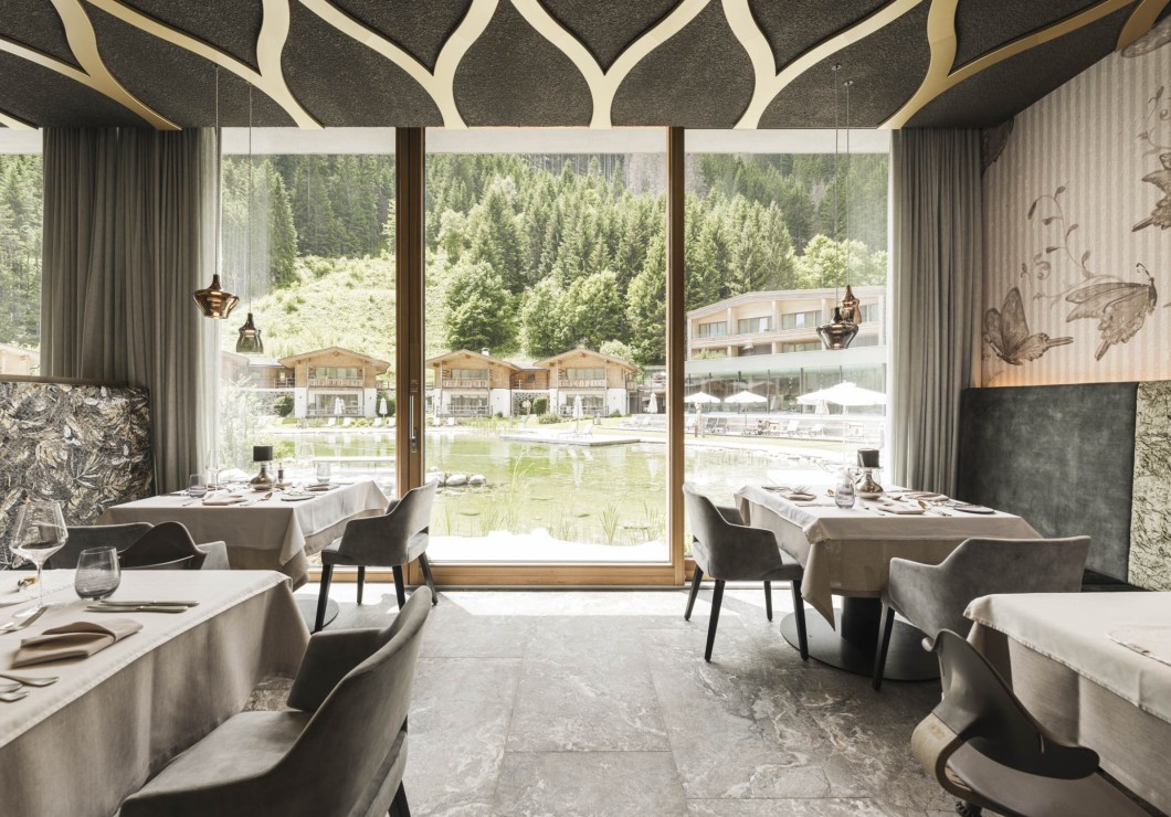 Una luminosa sala da pranzo moderna con grandi vetrate e vista sulla natura