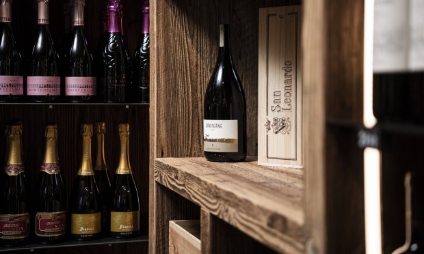 Scaffale di vini ben assortito con bottiglie pregiate in un ambiente elegante