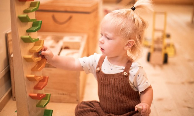 Un bambino piccolo gioca con una pista per biglie colorata in un'area giochi progettata con cura.