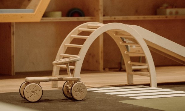 Un'elegante area giochi per bambini con pareti a nido d'ape e giochi in legno.