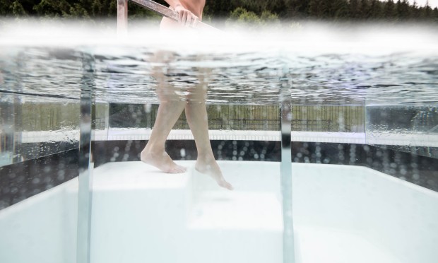 Frau betritt langsam das Eisbecken auf der Dachterasse
