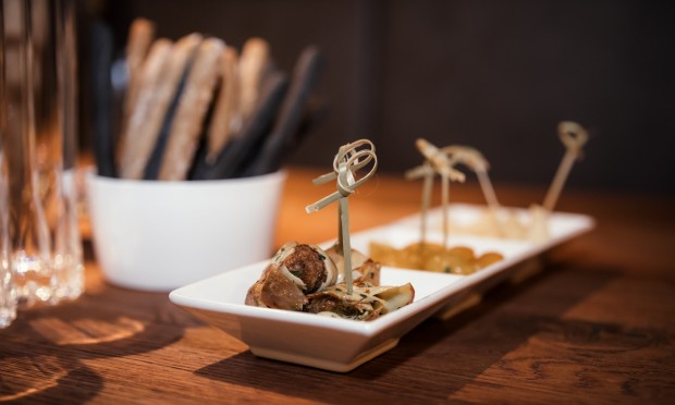 Selezione di finger food su tavolo di legno con illuminazione soffusa