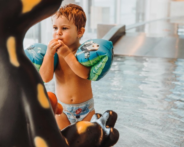Un bambino con braccioli che gioca nella piscina per bambini del Day Spa