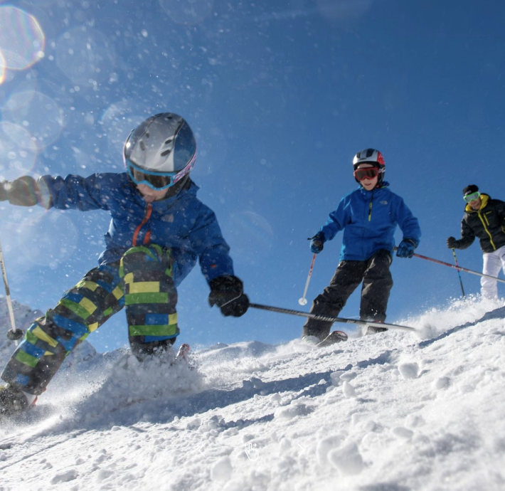Children practise skiing in the snow