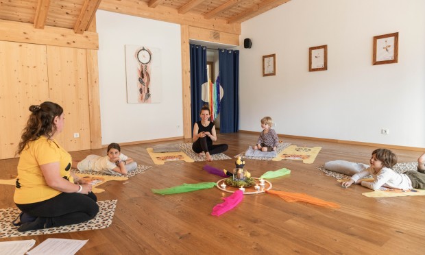 A mother with her children listens to the Family Relax stories in the Yoga Loft.