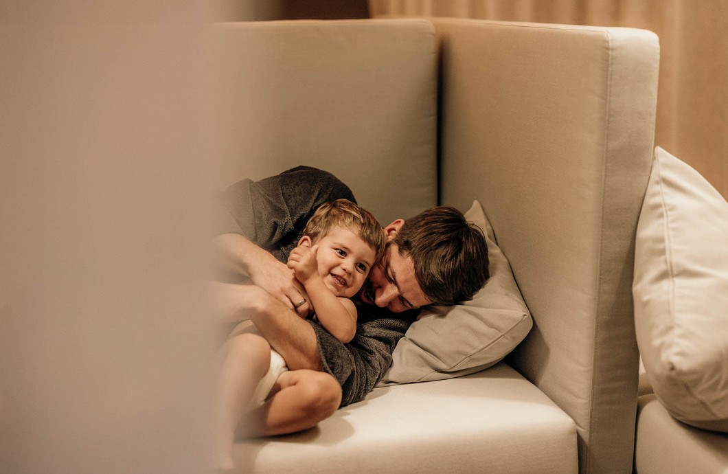 Un padre e un figlio si coccolano nell'area relax del Wellness Family Hotel in Alto Adige.