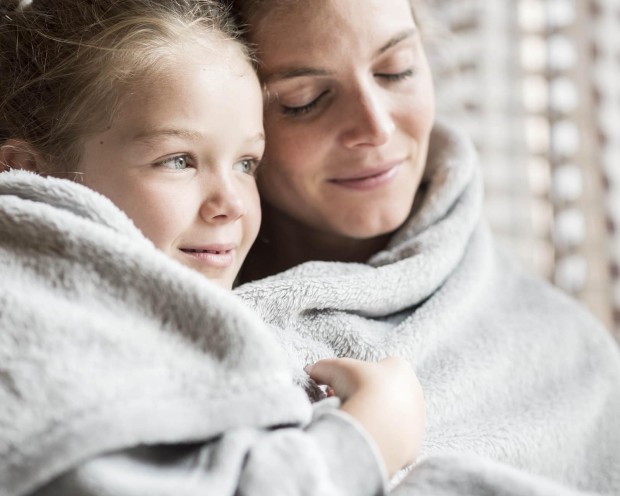 Daughter with mother wrapped in a blanket