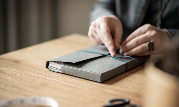 Mani di un dipendente che prende appunti su un taccuino e dispositivo digitale al Feuerstein.