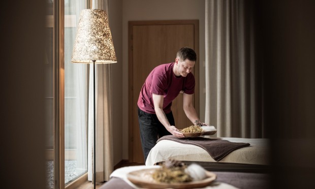 Dipendente che rifà il letto in una camera del Feuerstein sistemando la biancheria.